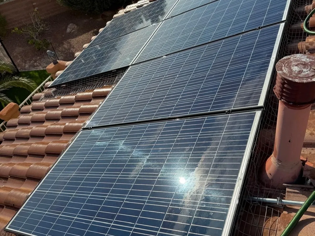 Solar panels on a tile roof with bird mesh sealing the perimeter